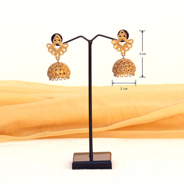 Our Classic Jhumka earrings made with unpolished brass placed on a grey background.